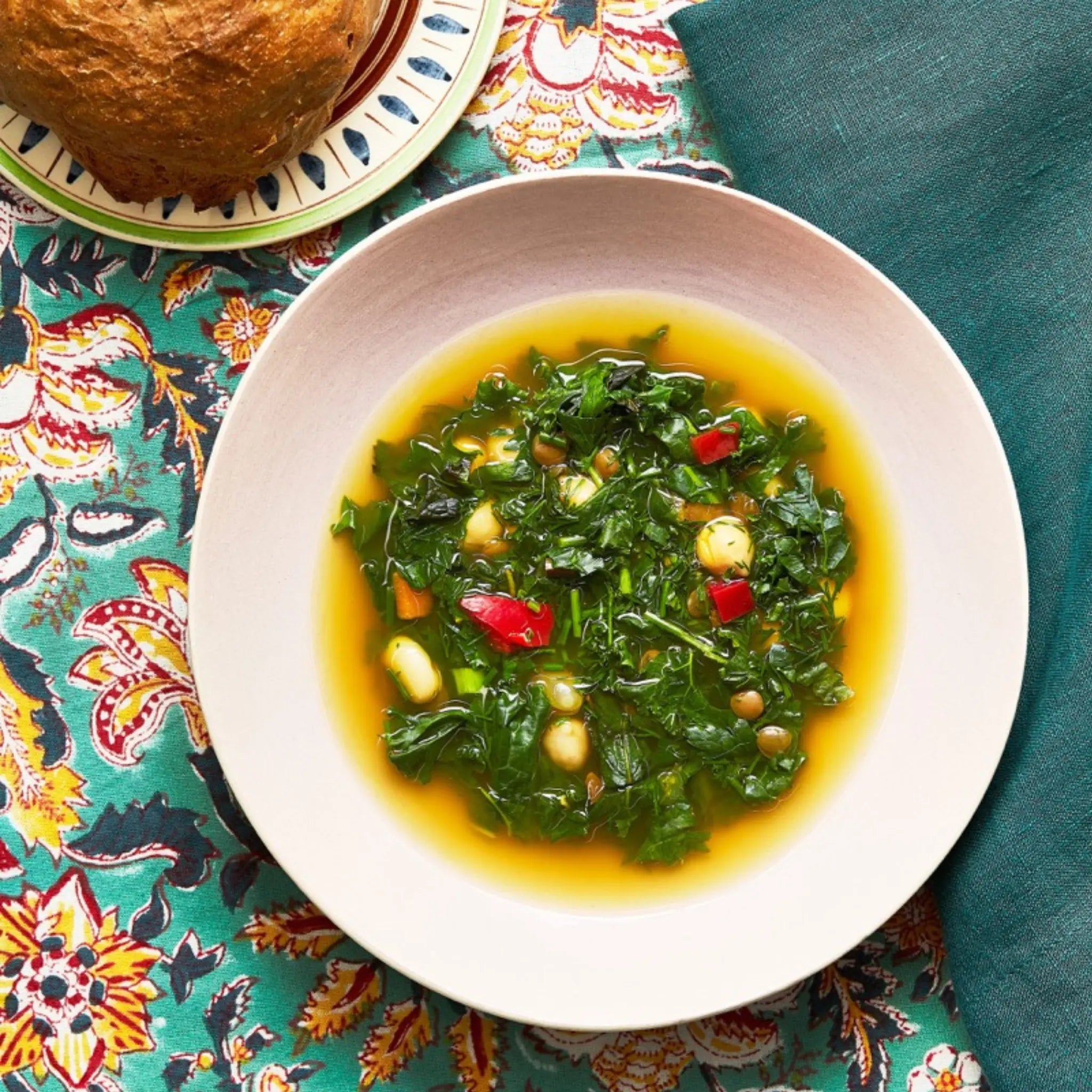 A closeup of a plate with Āsh Reshteh on a tablecloth for upcoming menu provided by Laroot World, an organic, local, gluten free New York City flexitarian, pescatarian, carnitarian, vegan, and vegetarian meal delivery service