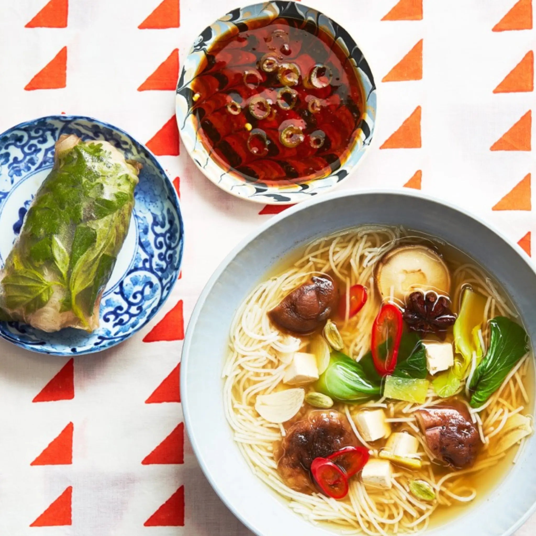A closeup of three dishes on a decorated tablecloth for upcoming menu provided by Laroot World, an organic, local, gluten free New York City flexitarian, pescatarian, carnitarian, vegan, and vegetarian meal delivery service