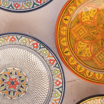 A close up of colored patterned plates on a white surface ready to be plated with organic, local, gluten free New York City flexitarian, pescatarian, carnitarian, vegan, and vegetarian meal delivery service foods offered by Laroot World.