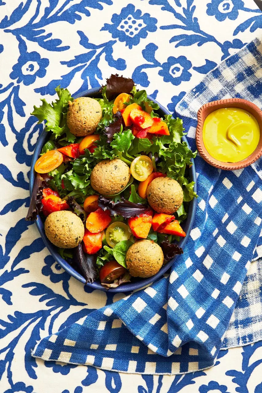 A closeup of a bowl of Falafel Mezze on a white and blue tablecloth for upcoming menu provided by Laroot World, an organic, local, gluten free New York City flexitarian, pescatarian, carnitarian, vegan, and vegetarian meal delivery service 