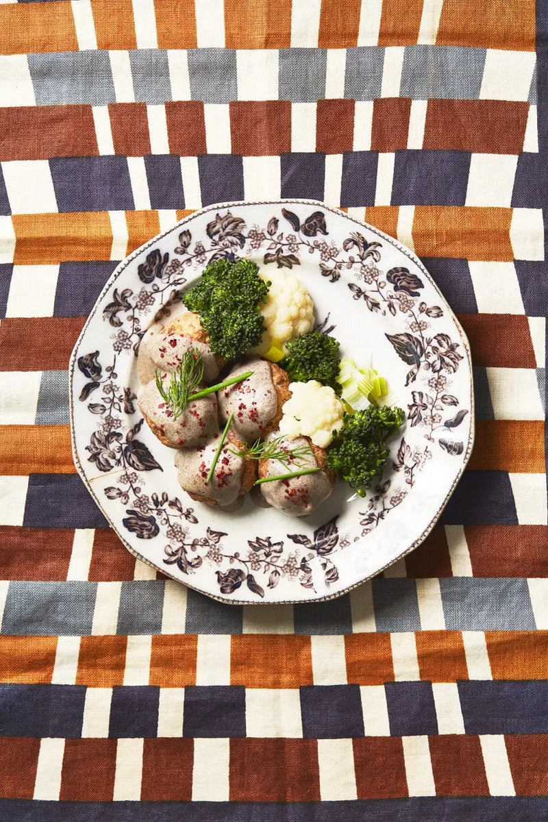 A bowl of Akvavit Meatballs on a decorated tablecloth for upcoming menu provided by Laroot World, an organic, local, gluten free New York City flexitarian, pescatarian, carnitarian, vegan, and vegetarian meal delivery service 
