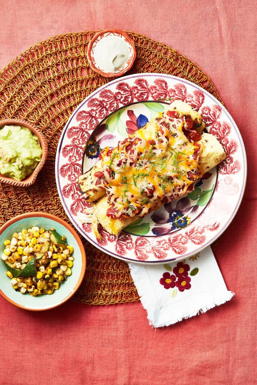 A plate with Chicken Enchiladas on a red tablecloth for upcoming menu provided by Laroot World, an organic, local, gluten free New York City flexitarian, pescatarian, carnitarian, vegan, and vegetarian meal delivery service 
