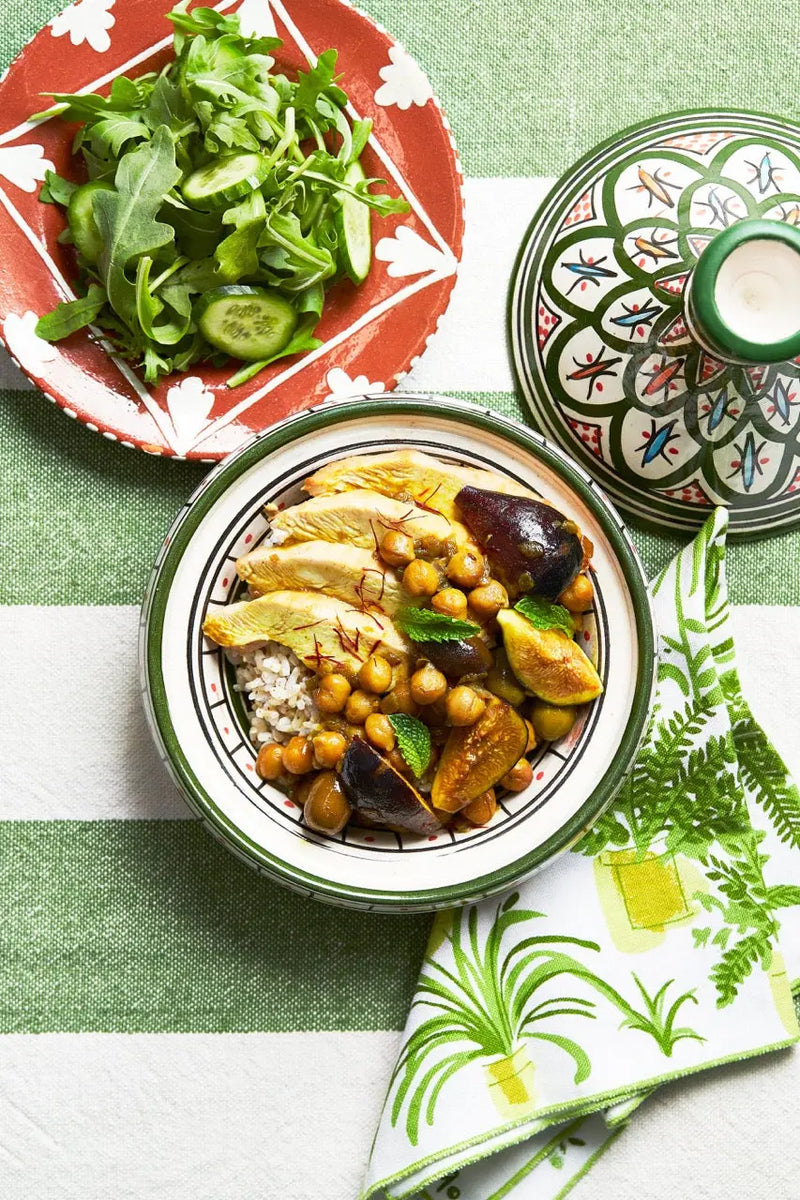 A plate with Chicken & Fig tagine on a green tablecloth for upcoming menu provided by Laroot World, an organic, local, gluten free New York City flexitarian, pescatarian, carnitarian, vegan, and vegetarian meal delivery service 