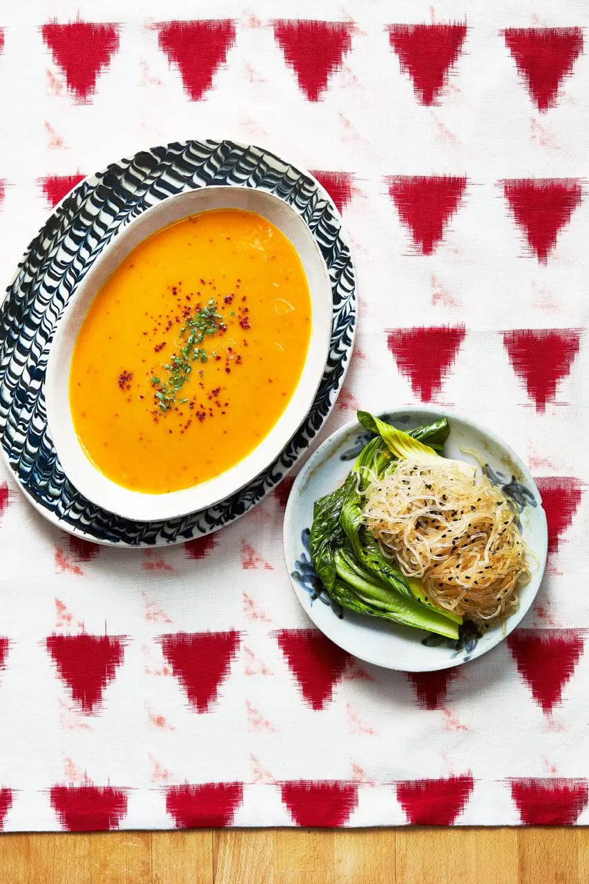 A plate with Spicy carrot Soup on a tablecloth for upcoming menu provided by Laroot World, an organic, local, gluten free New York City flexitarian, pescatarian, carnitarian, vegan, and vegetarian meal delivery service 