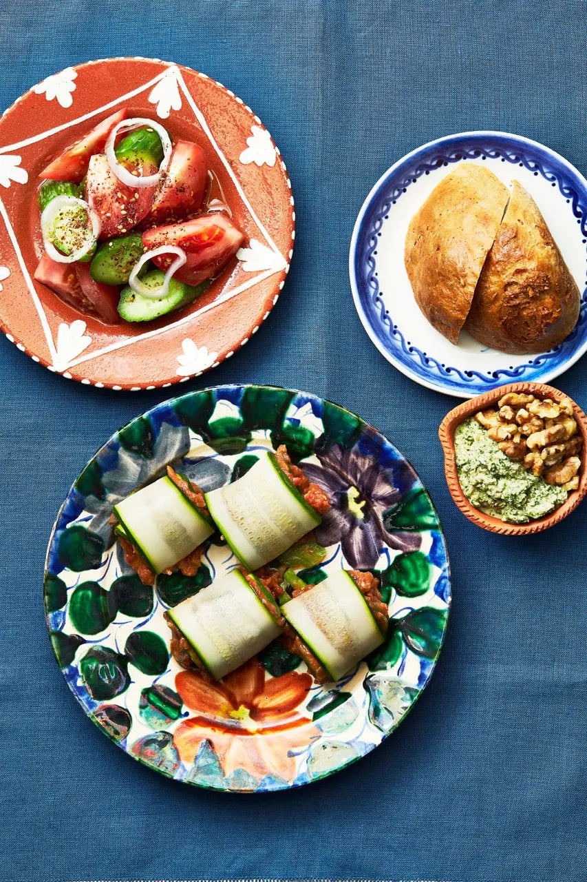 A plate of Zucchini Rolls on a blue tablecloth for upcoming menu provided by Laroot World, an organic, local, gluten free New York City flexitarian, pescatarian, carnitarian, vegan, and vegetarian meal delivery service 